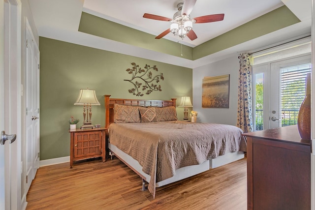 1410 Hurley Dr Unit 103, Sevierville, TN 37862 - bedroom with access to outside, wood finished floors, baseboards, a tray ceiling, and a ceiling fan