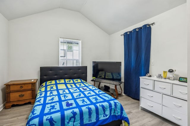 bedroom with light wood-style floors and vaulted ceiling