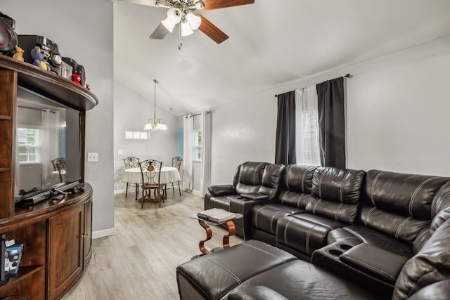 living area with ceiling fan, light wood finished floors, lofted ceiling, a chandelier, and baseboards