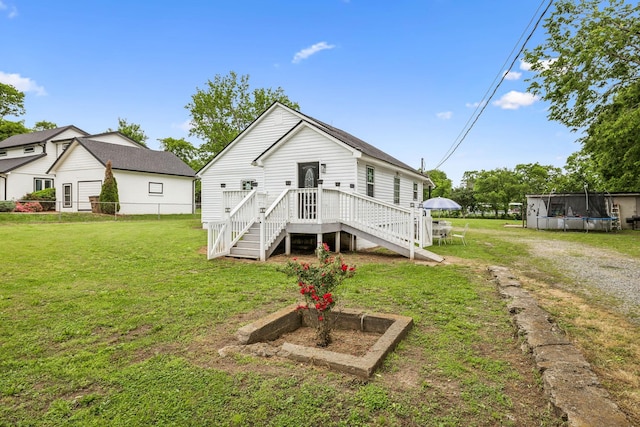 rear view of property featuring a trampoline