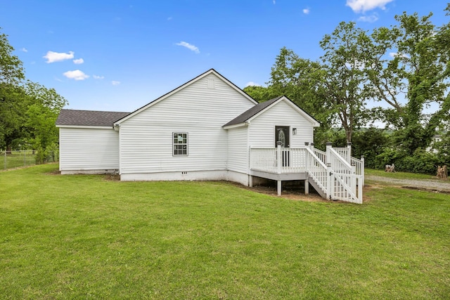 back of property featuring a yard and roof with shingles