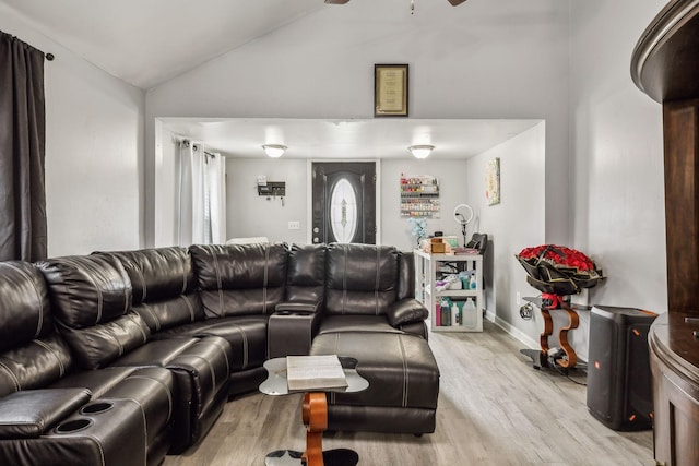 living area featuring vaulted ceiling, light wood-style floors, a ceiling fan, and baseboards