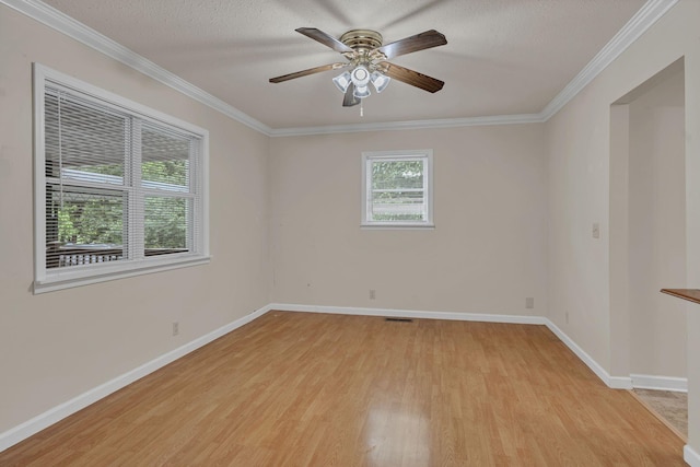 spare room with light wood-style flooring, a ceiling fan, baseboards, crown molding, and a textured ceiling