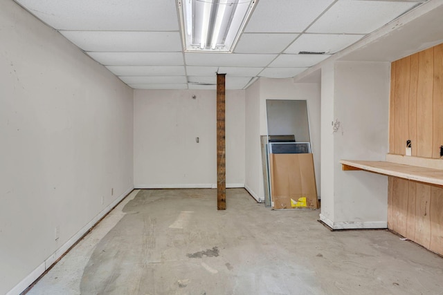 finished below grade area with a paneled ceiling and baseboards