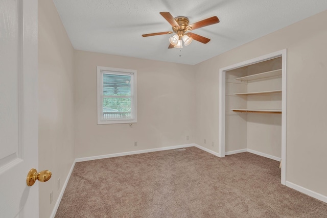 unfurnished bedroom with carpet floors, baseboards, a closet, a ceiling fan, and a textured ceiling