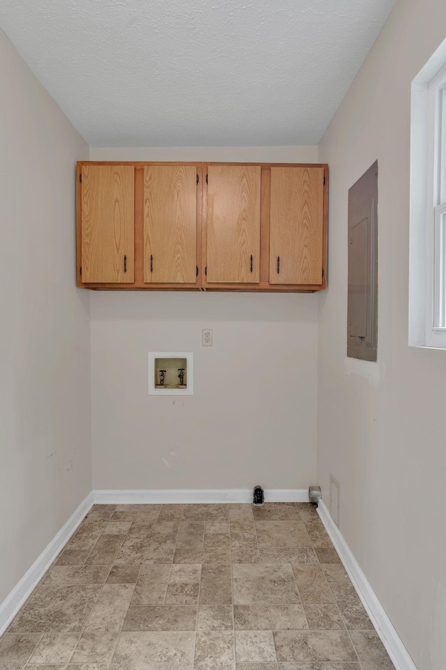 laundry area with cabinet space, electric panel, washer hookup, baseboards, and stone finish flooring
