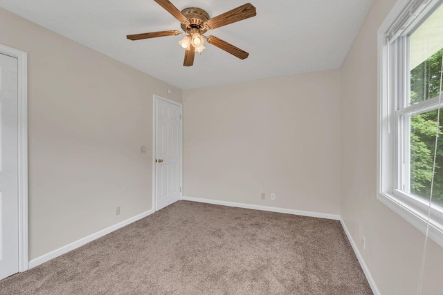 spare room featuring carpet flooring, baseboards, and a ceiling fan