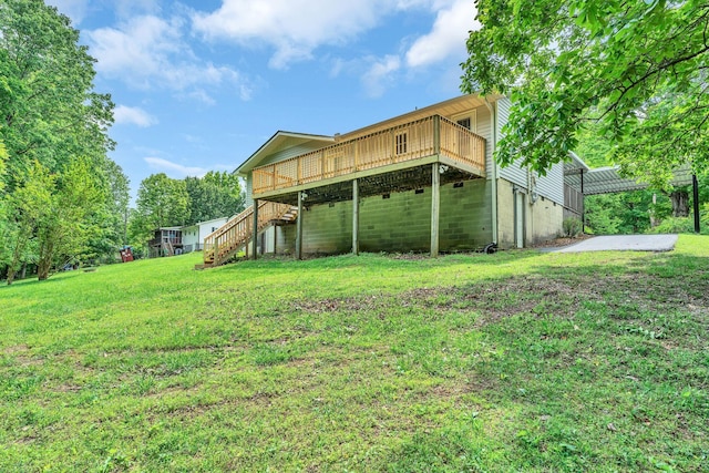 back of property with a deck, a lawn, and stairs