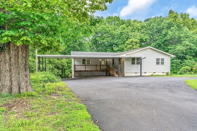 view of front facade featuring asphalt driveway, crawl space, and a carport