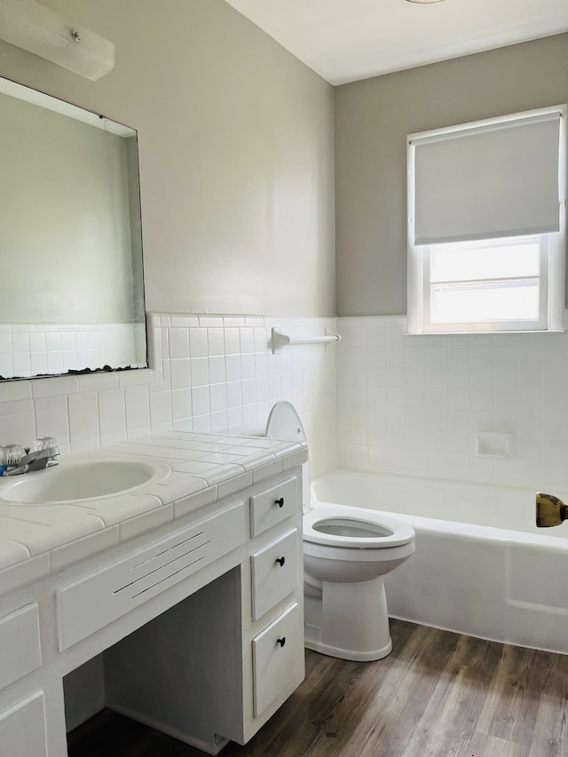 999 Mill St, Pulaski, TN 38478 - full bath featuring a bath, toilet, vanity, wood finished floors, and tile walls