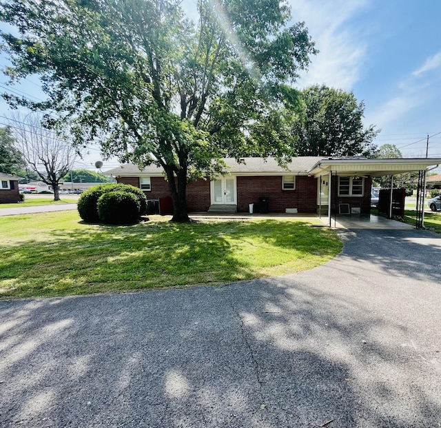 999 Mill St, Pulaski, TN 38478 - view of front of home with driveway, a front yard, brick siding, and a carport