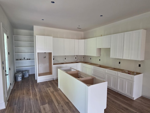 kitchen featuring a center island, dark wood-style floors, and white cabinets