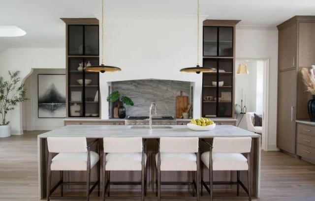 12 Middleton Park Ln, Nashville, TN 37215 - kitchen featuring light wood finished floors, open shelves, an island with sink, and a kitchen bar