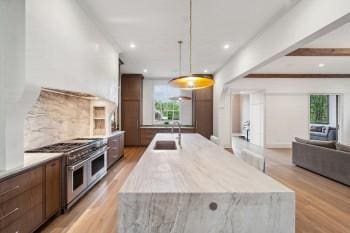 12 Middleton Park Ln, Nashville, TN 37215 - kitchen with double oven range, light wood-style flooring, a large island with sink, decorative backsplash, and recessed lighting