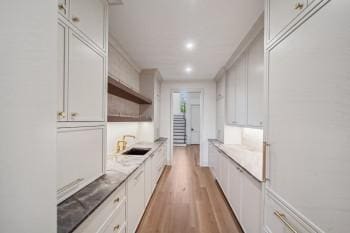 12 Middleton Park Ln, Nashville, TN 37215 - kitchen featuring a sink, light wood finished floors, light countertops, recessed lighting, and white cabinets