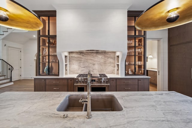 12 Middleton Park Ln, Nashville, TN 37215 - kitchen featuring stainless steel stove, wood finished floors, light stone counters, and decorative backsplash