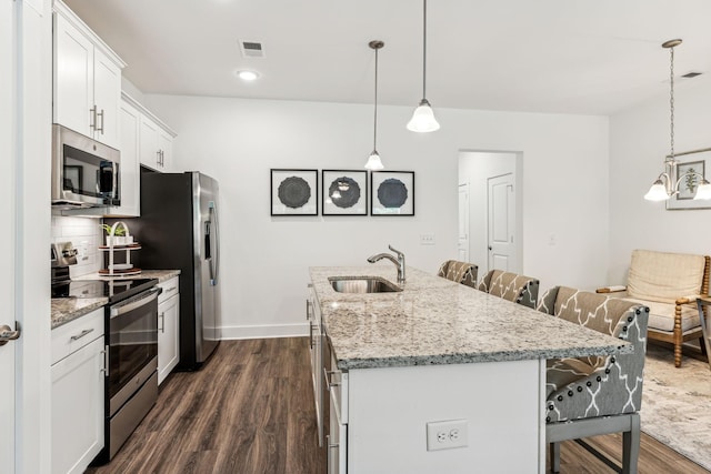 1115 Sweetleaf Dr, Franklin, TN 37064 - kitchen with stainless steel appliances, a sink, a breakfast bar area, an island with sink, and dark wood-type flooring