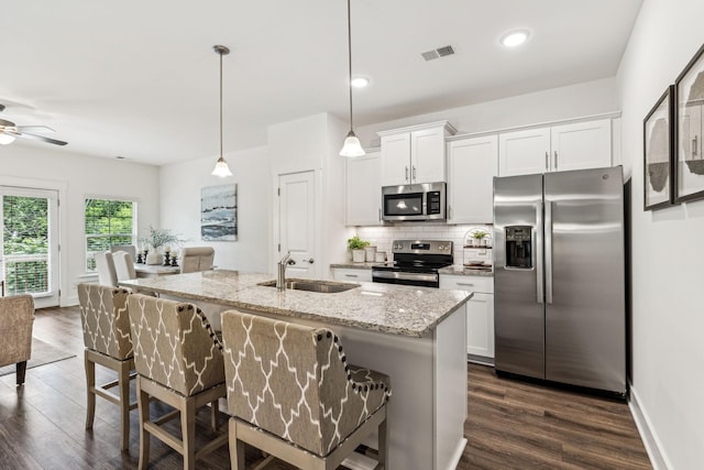 1115 Sweetleaf Dr, Franklin, TN 37064 - kitchen with stainless steel appliances, a sink, dark wood finished floors, tasteful backsplash, and light stone counters