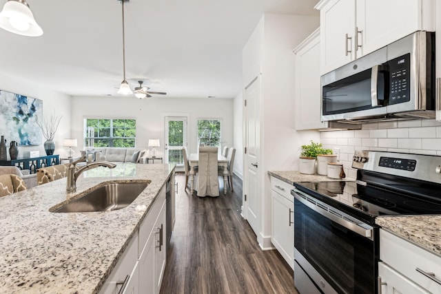 1115 Sweetleaf Dr, Franklin, TN 37064 - kitchen featuring appliances with stainless steel finishes, a sink, open floor plan, and dark wood-style flooring