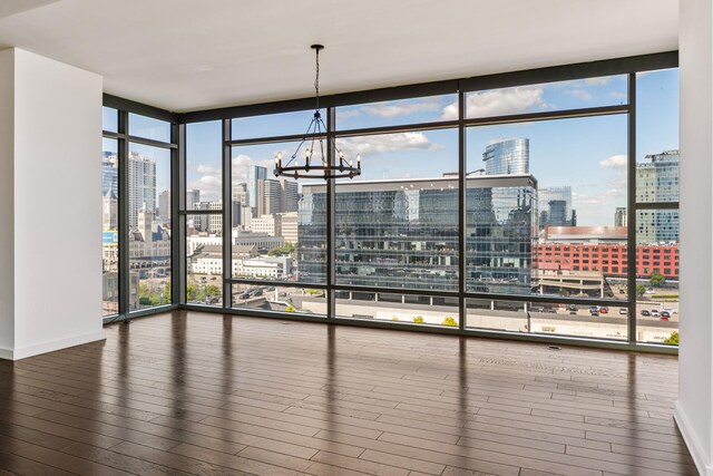 1212 Laurel St Unit 701, Nashville, TN 37203 - unfurnished dining area with a skyline view, hardwood / wood-style flooring, floor to ceiling windows, baseboards, and a chandelier