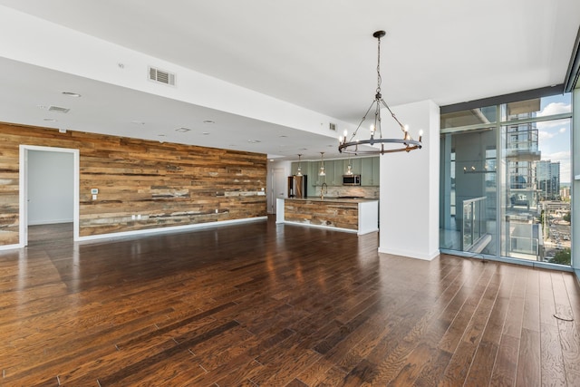 1212 Laurel St Unit 701, Nashville, TN 37203 - unfurnished living room featuring a chandelier, wood walls, floor to ceiling windows, dark wood-style flooring, and a sink