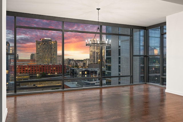 1212 Laurel St Unit 701, Nashville, TN 37203 - empty room featuring a wall of windows, hardwood / wood-style floors, a chandelier, and a city view