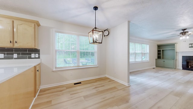 618 Cookstown Dr, Smyrna, TN 37167 - unfurnished dining area featuring light wood finished floors, a textured ceiling, a fireplace, a ceiling fan, and a chandelier
