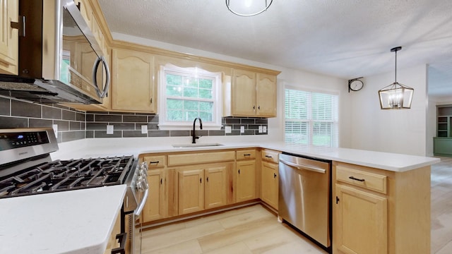 618 Cookstown Dr, Smyrna, TN 37167 - kitchen with appliances with stainless steel finishes, light brown cabinetry, a sink, a peninsula, and decorative backsplash