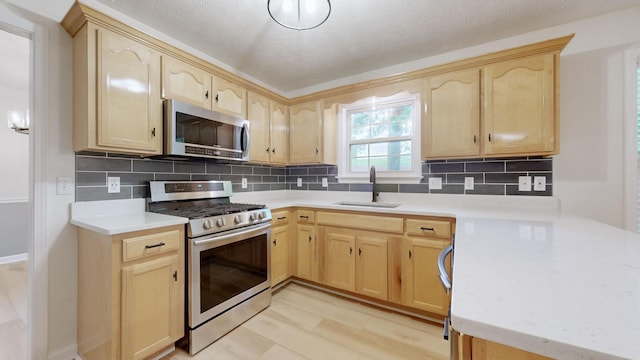 618 Cookstown Dr, Smyrna, TN 37167 - kitchen with appliances with stainless steel finishes, light brown cabinetry, a sink, light countertops, and a textured ceiling