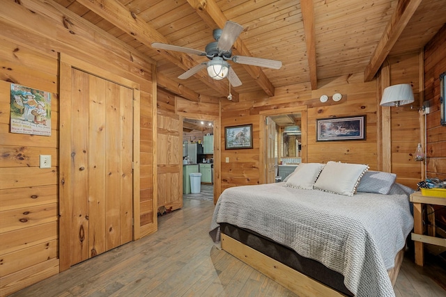 154 Whitetail Ln, Belvidere, TN 37306 - bedroom with wood walls, wooden ceiling with exposed beams, and light wood-style floors
