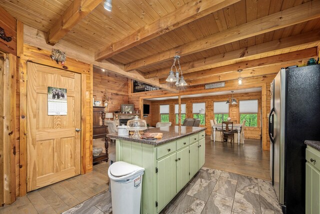 154 Whitetail Ln, Belvidere, TN 37306 - kitchen with green cabinetry, freestanding refrigerator, wood ceiling with exposed beams, a kitchen island, and wooden walls