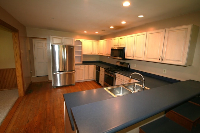 603 Canterbury Trl, Mount Juliet, TN 37122 - kitchen with stainless steel appliances, a sink, dark countertops, wood finished floors, and open shelves