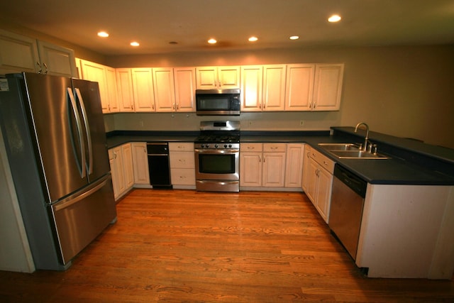 603 Canterbury Trl, Mount Juliet, TN 37122 - kitchen with stainless steel appliances, a sink, dark countertops, recessed lighting, and wood finished floors