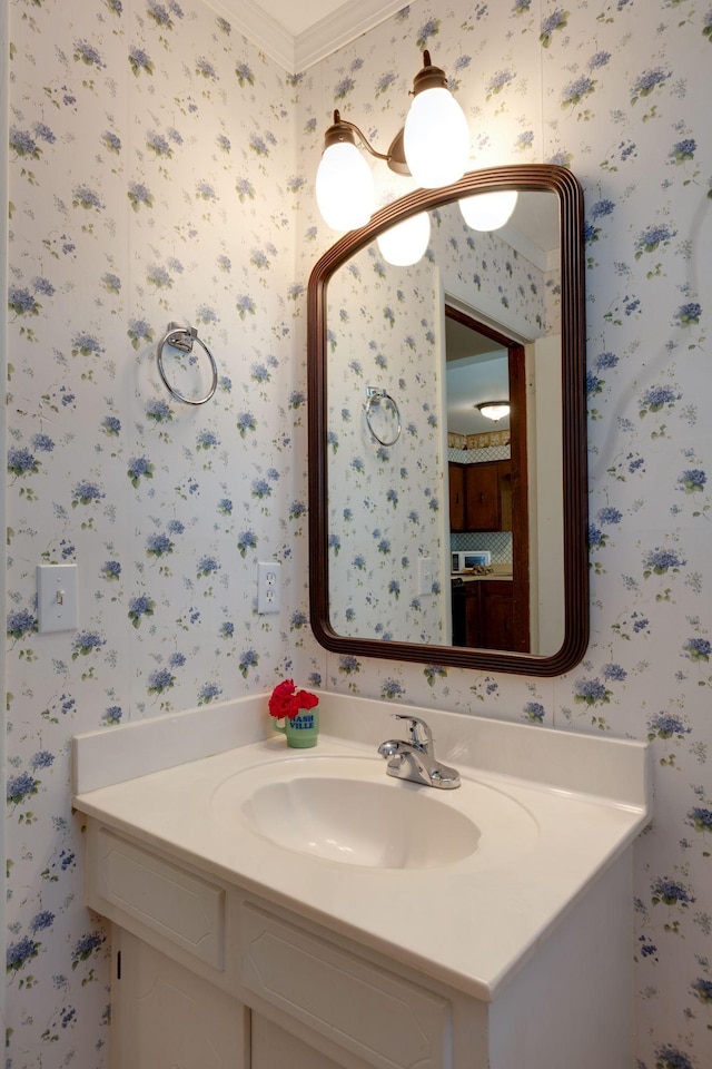 bathroom featuring wallpapered walls, vanity, and crown molding