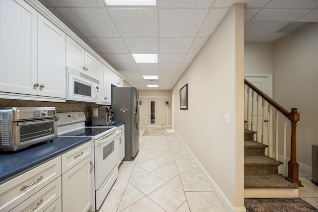 575 Homestead Ln, Henderson, TN 38340 - kitchen featuring white appliances, a paneled ceiling, dark countertops, light tile patterned flooring, and baseboards