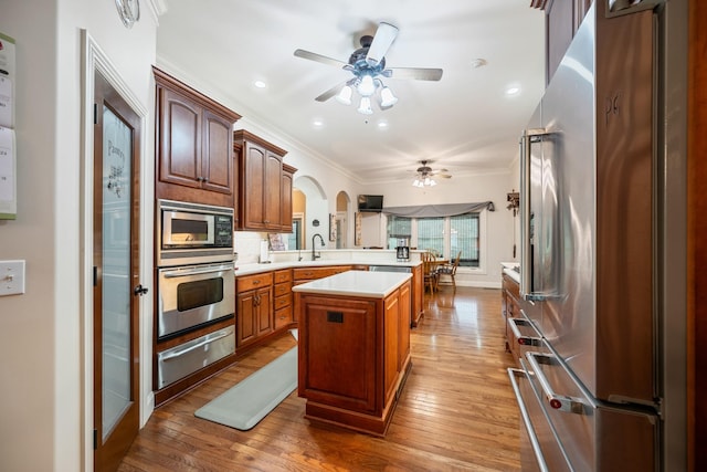575 Homestead Ln, Henderson, TN 38340 - kitchen featuring appliances with stainless steel finishes, a warming drawer, ceiling fan, a peninsula, and ornamental molding
