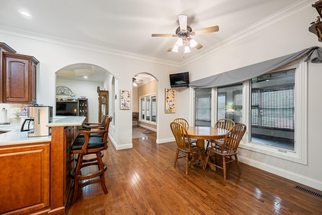 575 Homestead Ln, Henderson, TN 38340 - dining room with ceiling fan, dark wood-type flooring, baseboards, ornamental molding, and arched walkways