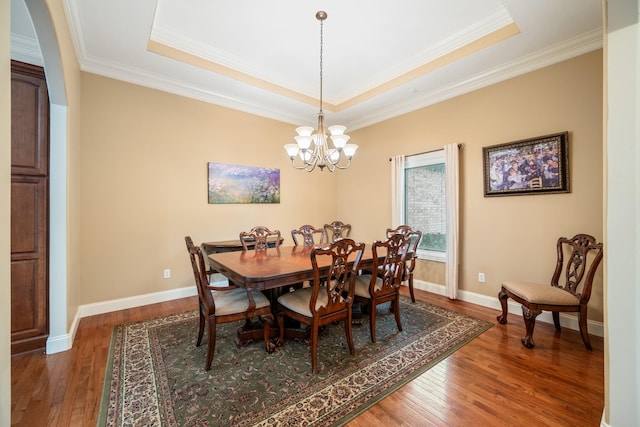 575 Homestead Ln, Henderson, TN 38340 - dining room featuring wood finished floors, a tray ceiling, arched walkways, ornamental molding, and a chandelier
