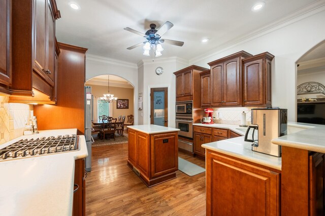 575 Homestead Ln, Henderson, TN 38340 - kitchen with stainless steel appliances, arched walkways, a warming drawer, light countertops, and light wood finished floors