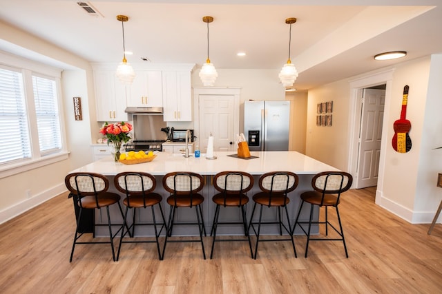 1822 Jefferson St, Nashville, TN 37208 - kitchen featuring stainless steel refrigerator with ice dispenser, under cabinet range hood, baseboards, white cabinets, and light wood-style floors