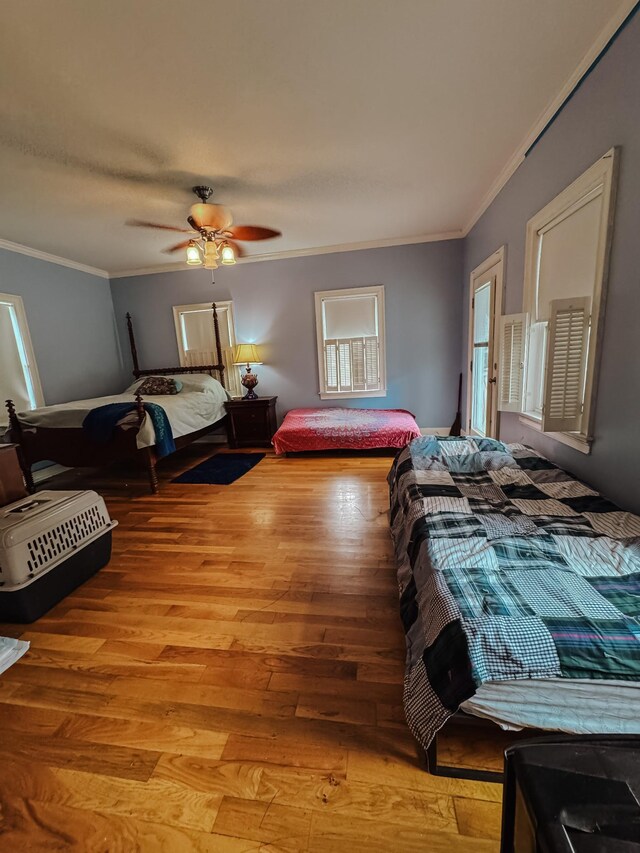 209 Main St, Cumberland City, TN 37050 - bedroom with ornamental molding, wood finished floors, a ceiling fan, and multiple windows