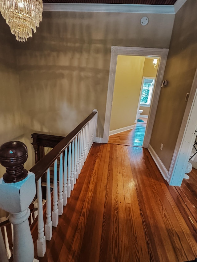 209 Main St, Cumberland City, TN 37050 - hall with an upstairs landing, a chandelier, wood-type flooring, baseboards, and crown molding