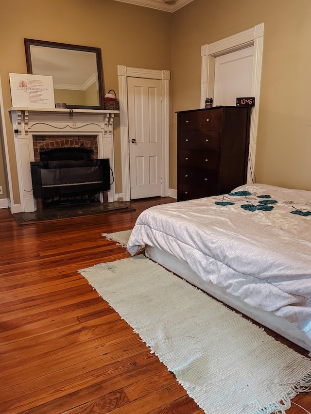 209 Main St, Cumberland City, TN 37050 - bedroom featuring ornamental molding, a fireplace, and wood finished floors