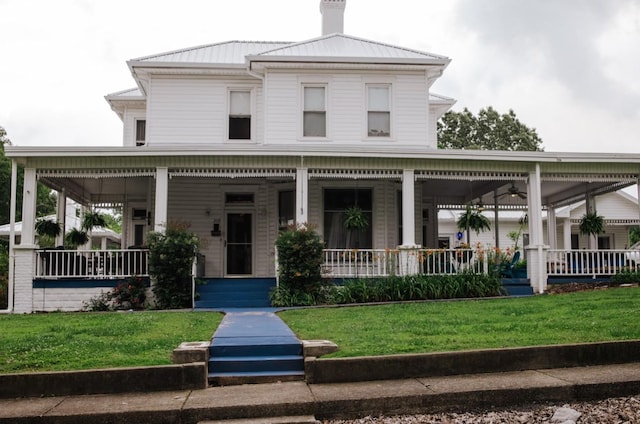 209 Main St, Cumberland City, TN 37050 - view of front of home with covered porch, a front yard, a chimney, and metal roof