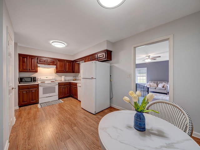 100 Oak Ave, Dickson, TN 37055 - kitchen featuring white appliances, under cabinet range hood, light wood finished floors, light countertops, and baseboards