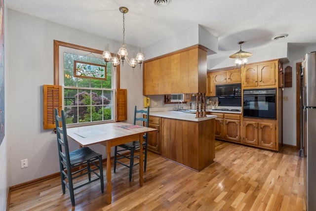 103 Forrest Hills Dr, Dickson, TN 37055 - kitchen with black appliances, a chandelier, a peninsula, brown cabinetry, and light wood-style floors