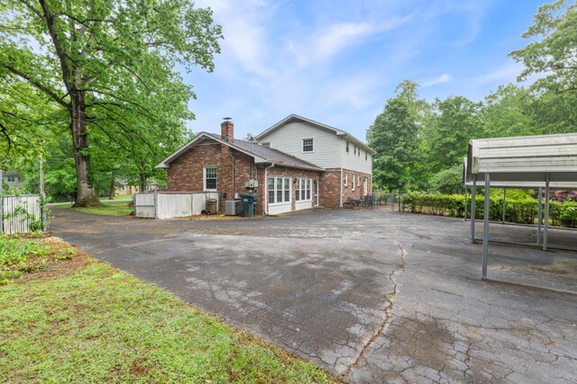 103 Forrest Hills Dr, Dickson, TN 37055 - back of property featuring a chimney, brick siding, driveway, and fence