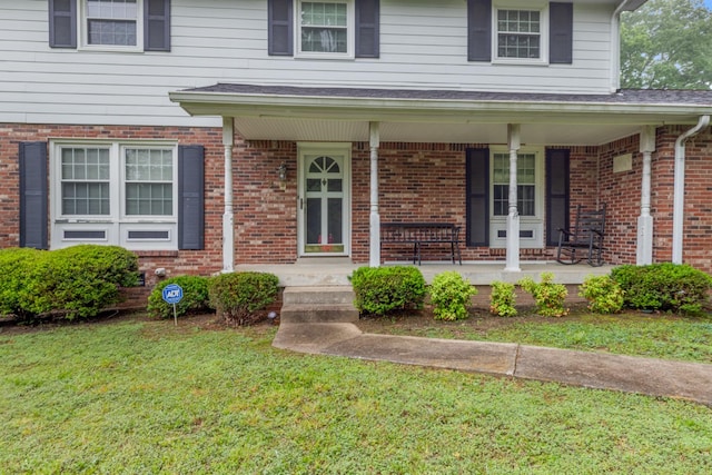 103 Forrest Hills Dr, Dickson, TN 37055 - view of exterior entry with covered porch, a lawn, and brick siding