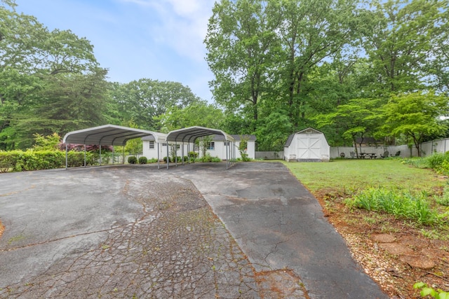 103 Forrest Hills Dr, Dickson, TN 37055 - view of front of house featuring a storage unit, asphalt driveway, a detached carport, and an outdoor structure