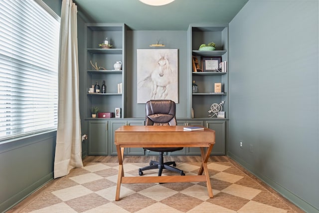 home office featuring baseboards and built in features